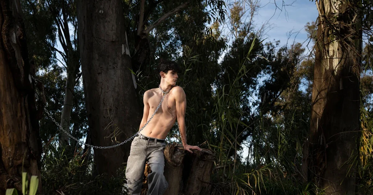 Fine art photography series PERMANENC by Arjan Spannenburg. A close-up from the artwork POSSESSION of a young man chained in a landscape, symbolizing the human struggle to preserve youth and stop the passage of time.